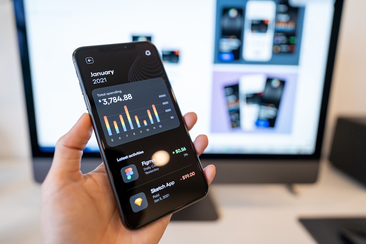 A mobile finance app interface designed and built for iOS and Android, shown on a phone in hand